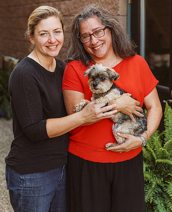 two women holding a dog